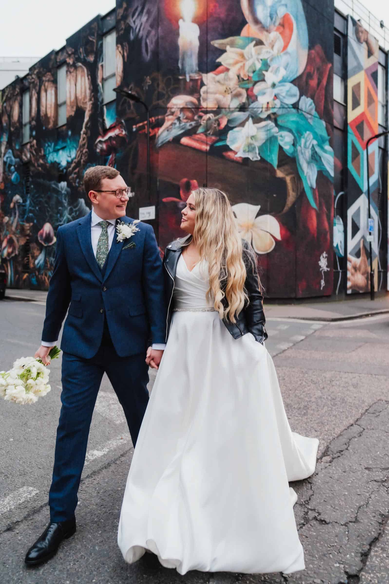 Bride and groom riding vintage fairground carousel, colourful fun London wedding at Shoreditch Studios