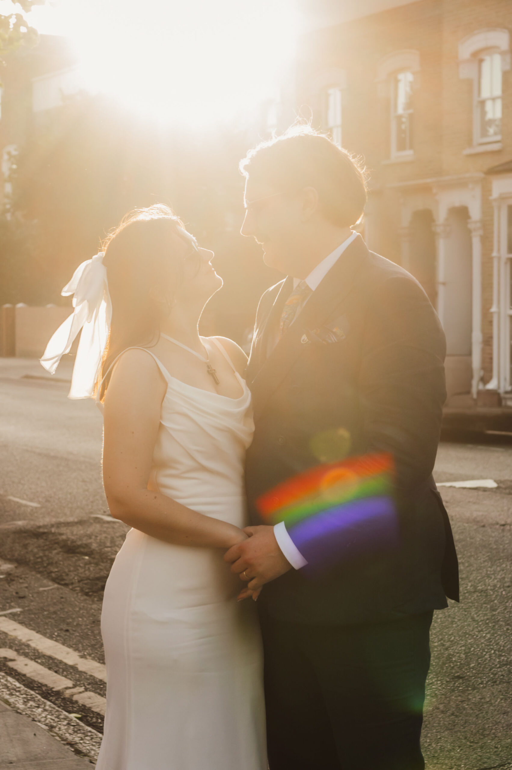 Newly married couple at Clapton Country Club in East London in the golden hour with a rainbow lens flare