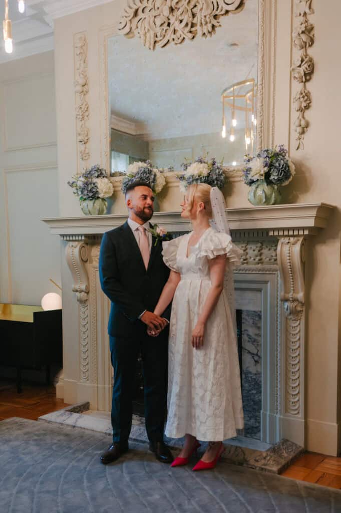 Romantic wedding scene featuring a bride and groom in stylish attire at a luxurious venue.