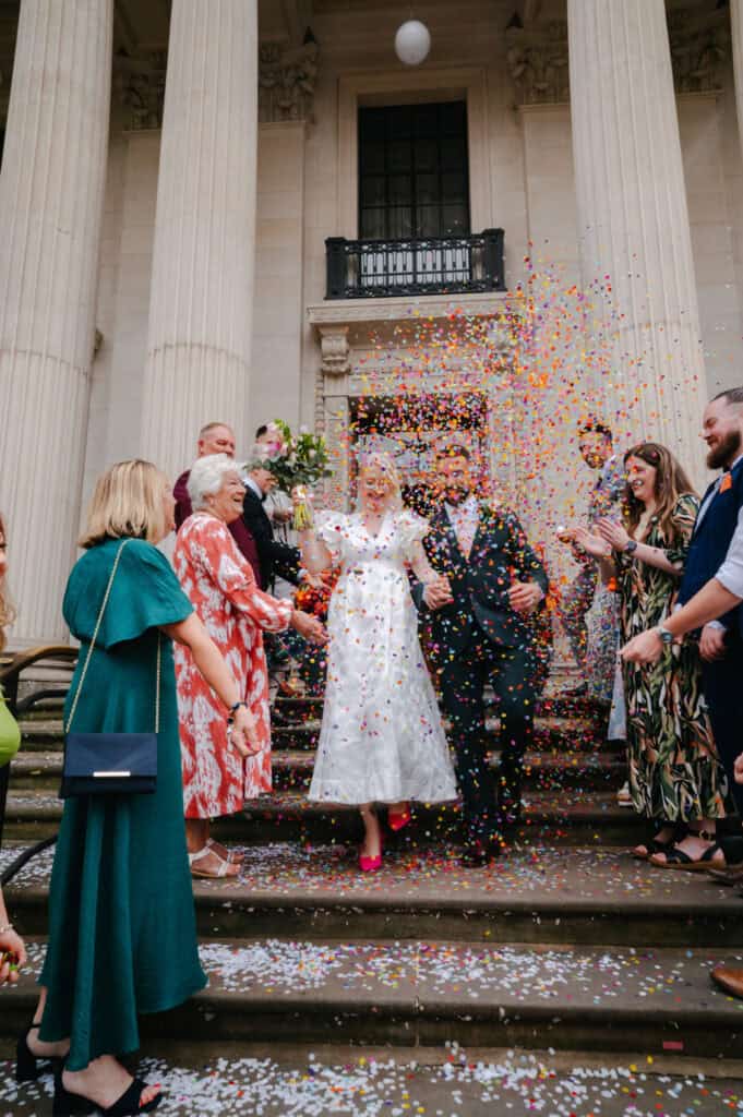 Romantic wedding scene featuring a bride and groom in stylish attire at a luxurious venue.