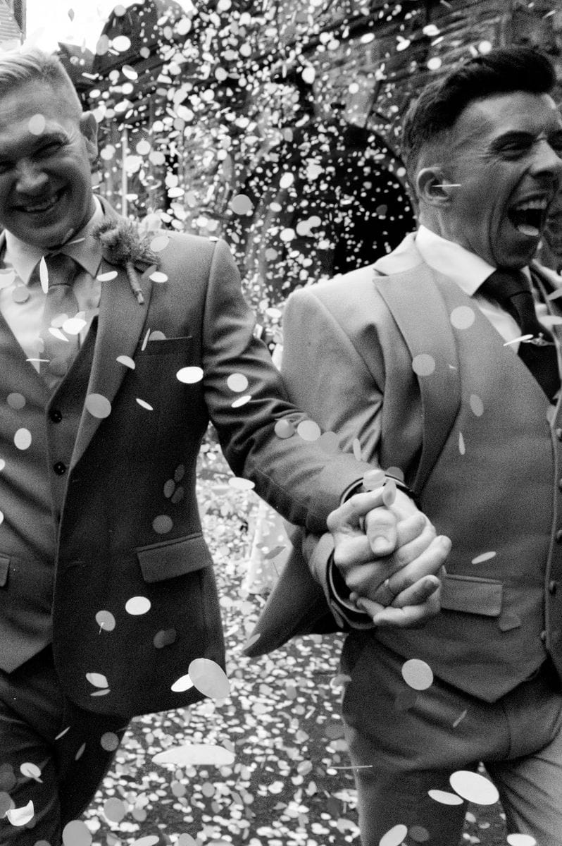 Two grooms in confetti shower