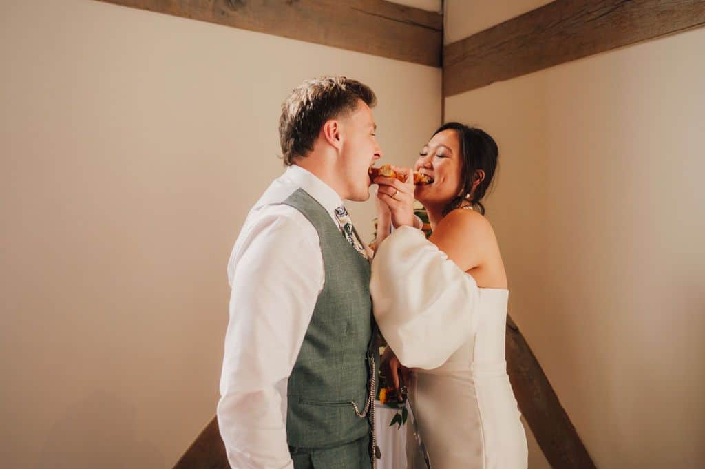 Couple sharing food at barn wedding